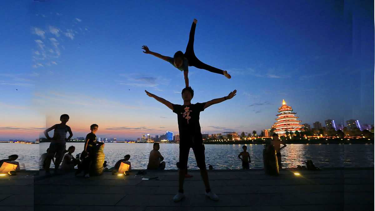 Members of the Sichuan Province Acrobatic Troupe practice outdoors in the evening to avoid the summer heat, in Suining, in China`s southwest Sichuan province on July 17, 2017. AFP