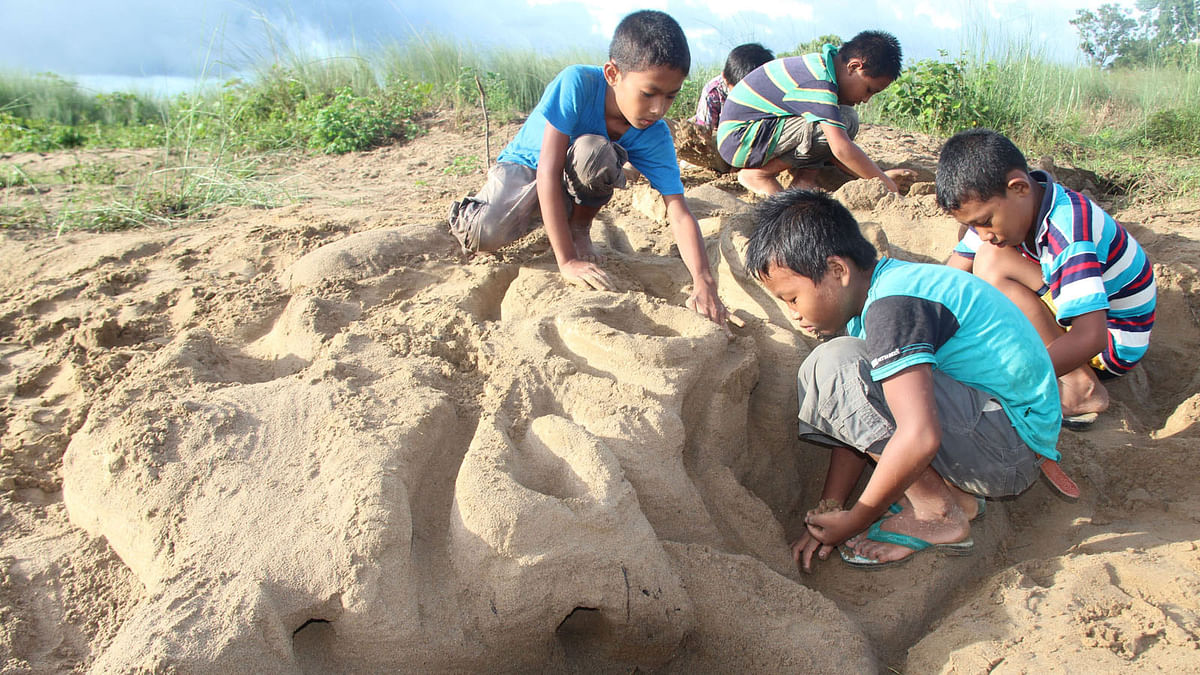 Children making sand castle near the bank of Chengi river in Khagrachhari on Friday. Photo: Neerab Chowdhury