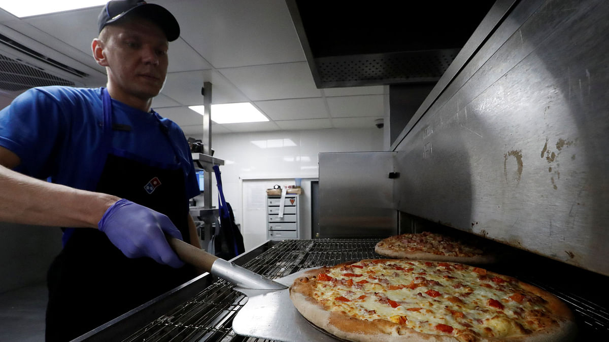 A staff member prepares pizzas at a Domino`s Pizza restaurant in Moscow, Russia. Photo: Reuters