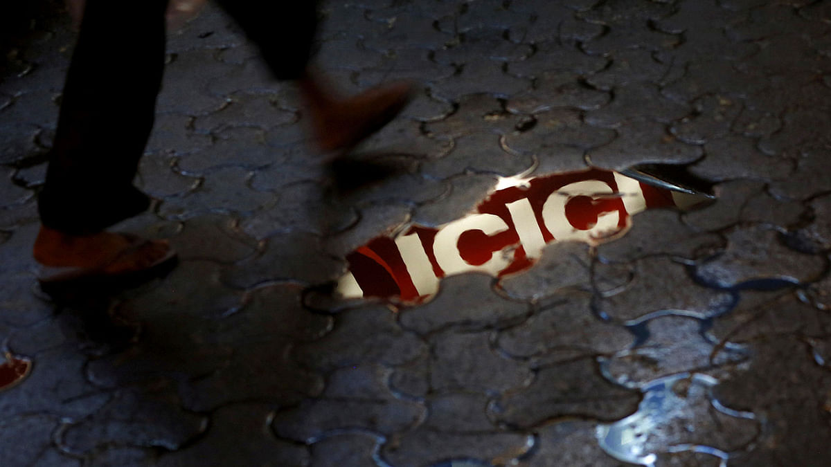 ICICI bank signboard is reflected in a puddle on a street in New Delhi. Reuters