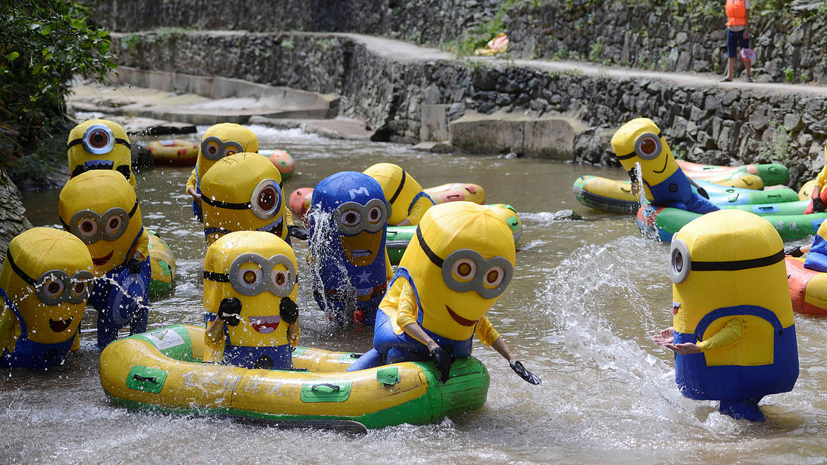 People in Minions costumes cool off at a riverside scenic zone on a hot day in Lianyuan. Reuters