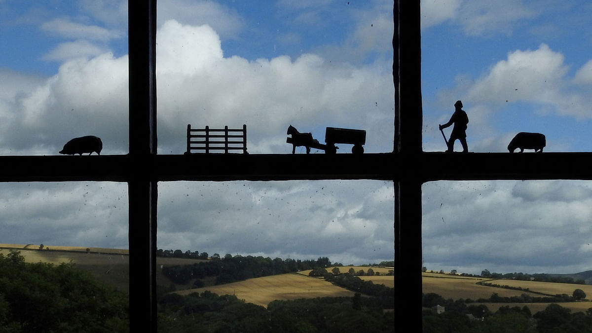Miniature agricultural figures are seen on a window of a cottage overlooking farmland in Shropshire, central England. Reuters