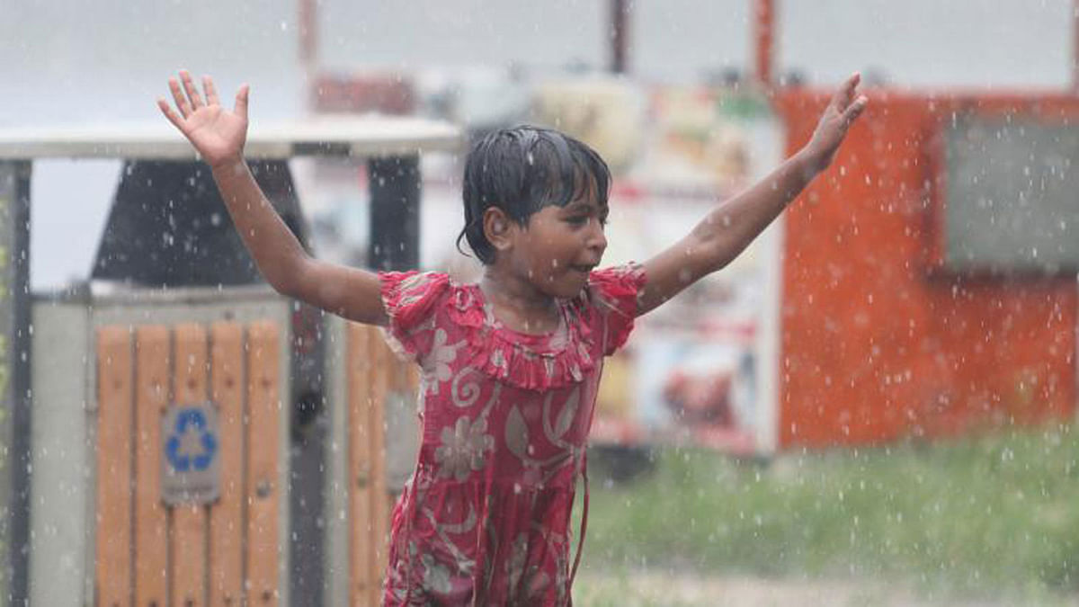 A child playing in rains on Saturday at Hatirjheel in the capital. Photo: Abdus Salam