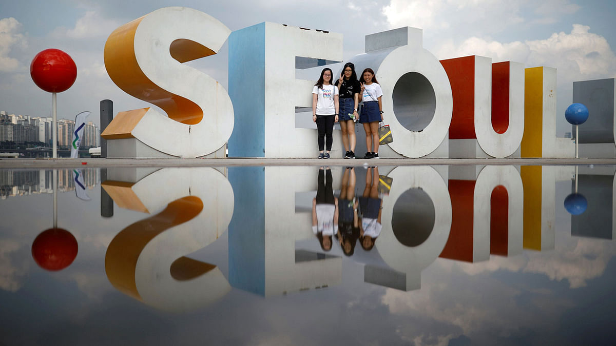 Tourists pose for photographs at the Han river park in Seoul, South Korea, 1 August. Photo: Reuters