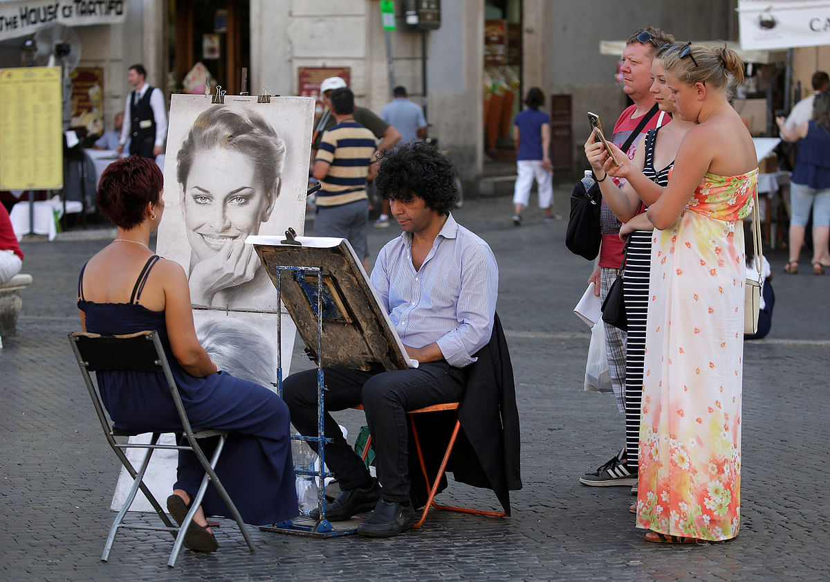 A street painter works makes a portrait of a tourist in downtown Rome. Reuters