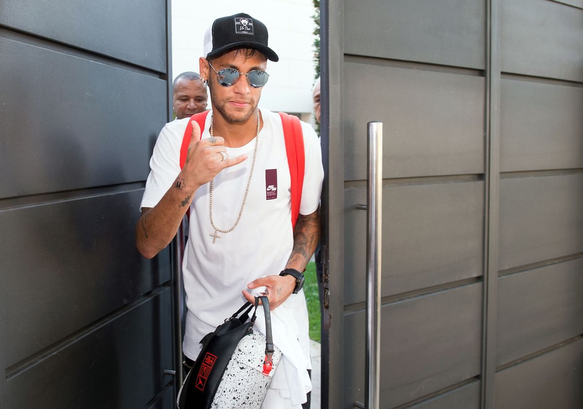 Brazilian forward Neymar gestures as he leaves his home in Barcelona to go to the airport, on August 4, 2017.