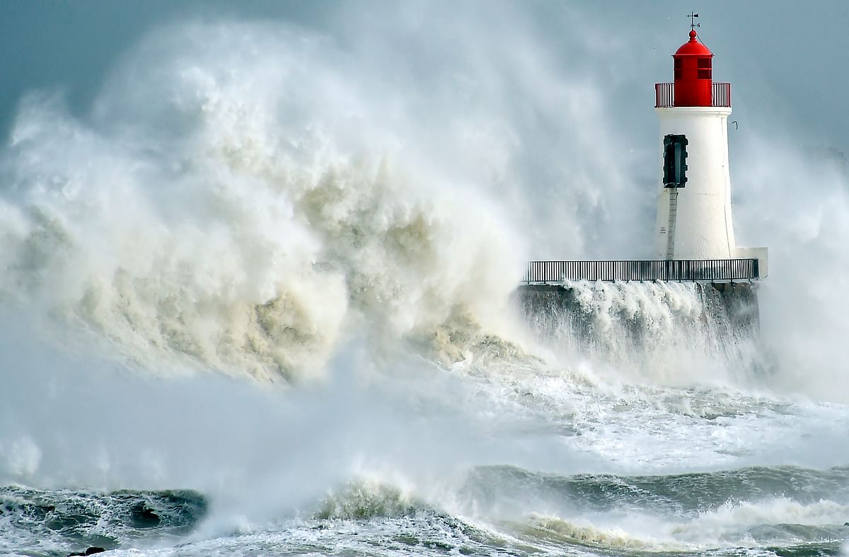 Waves breaking against a pier and a lighthouse in Les Sables-d’Olonne, western France. AFP file photo