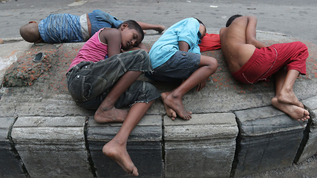 Four children sleeping on a concrete road divider on Friday morning in the capital’s Gulistan. Photo: Abdus Salam
