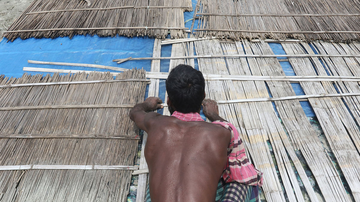 A man repairing his thatched rroftop on Friday in Munshiganj. Photo: Abdus Salam