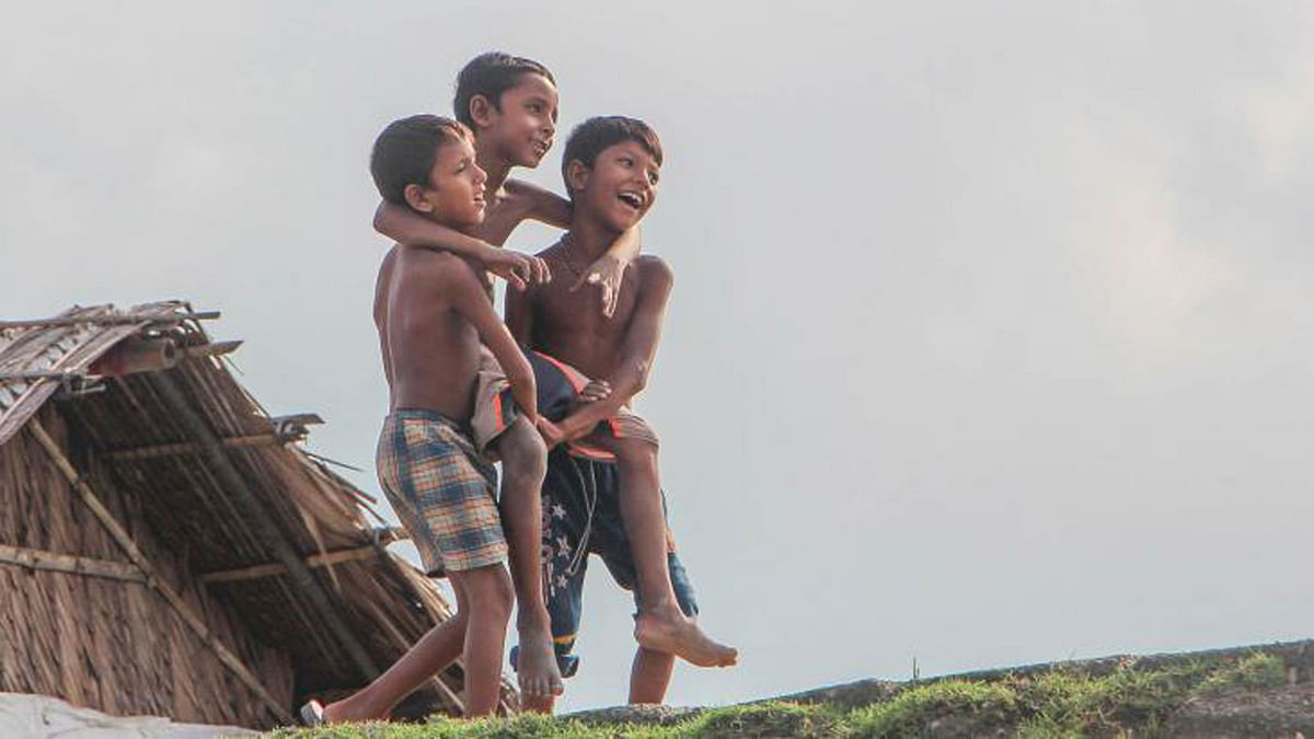Three boys playing with each other on 5 August in Khulna’s Dakop upazila. Photo: Saddam Hossain