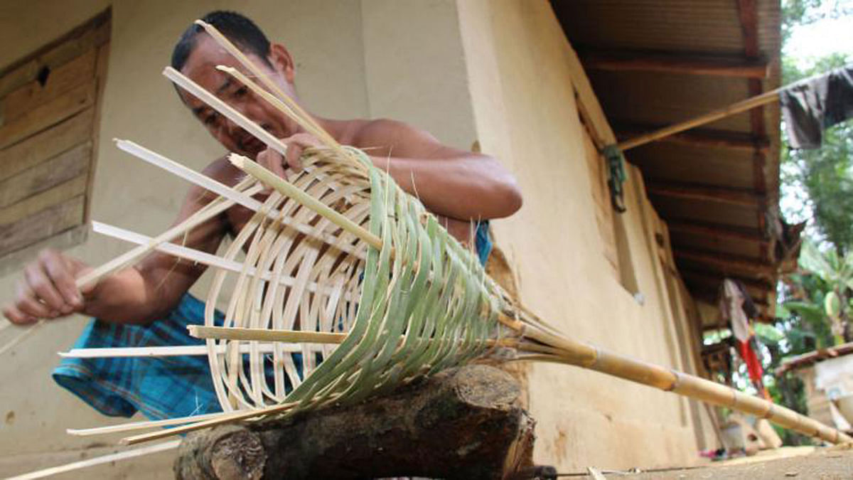 An indigenous man making a chicken cage from weave bamboo in Khagrachhari on 5 August. Photo: Neerab Chowdhury