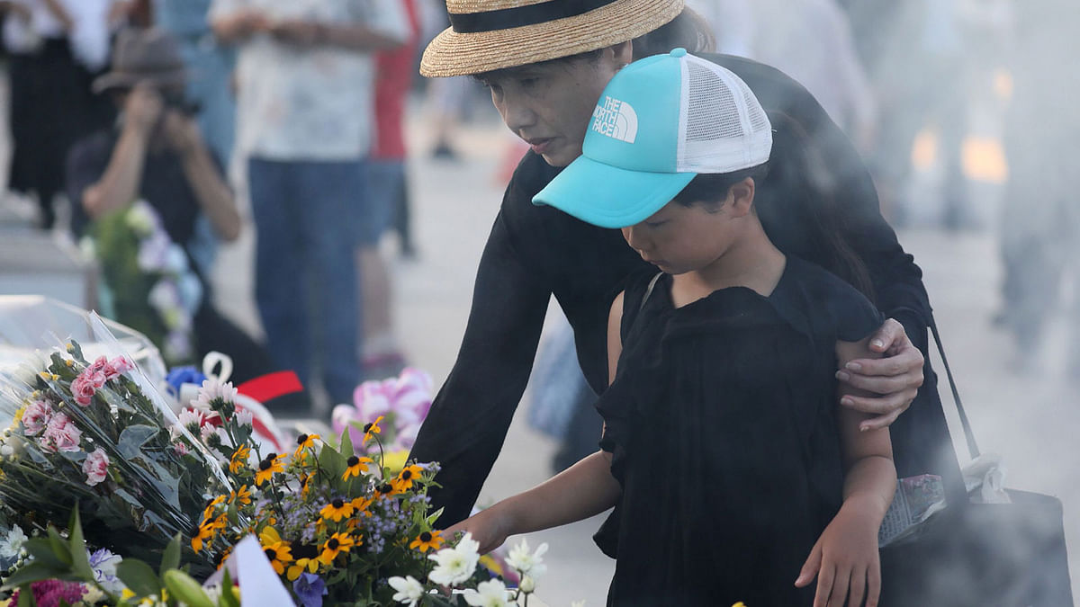 People lay flowers and offer prayers early morning prior to the 72nd anniversary memorial service for the atomic bomb victims at the Peace Memorial Park in Hiroshima on 6 August, 2017. Photo: AFP