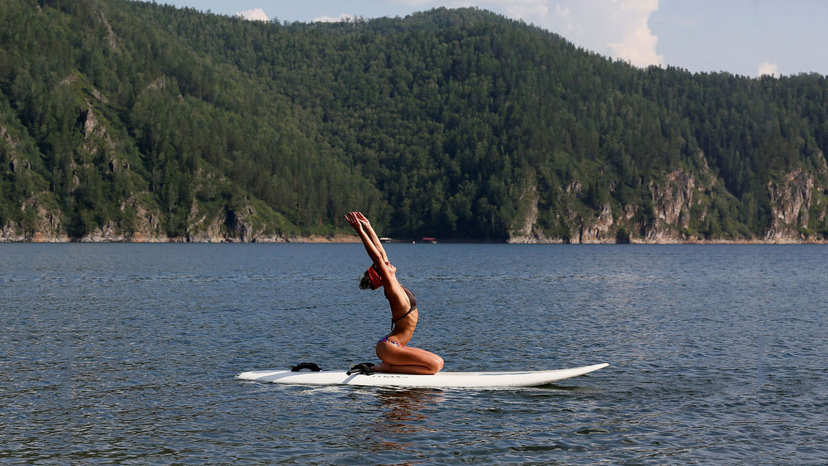 Yulia Boyarintseva, a master of snow boarding and snow kiting sports, practices Float Board Yoga on the Yenisei River on a hot summer day as she rests in a summer camp outside the Siberian city of Krasnoyarsk. Reuters