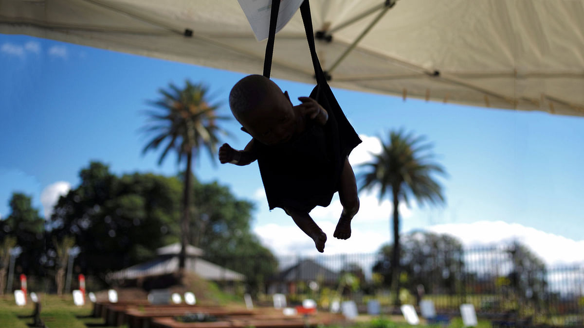 A baby doll hangs from a scale used to track the weight of infants in a mock medical tent at the `Refugee Camp in my Neighbourhood` installation at a Sydney park in Australia. Reuters