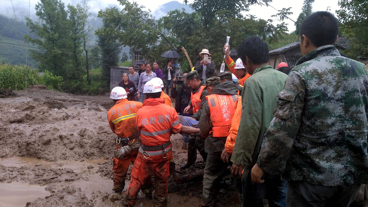 Rescuers carry a survivor at the site of a landslide in Puge in China`s southwestern Sichuan province on August 8, 2017. Photo: AFP
