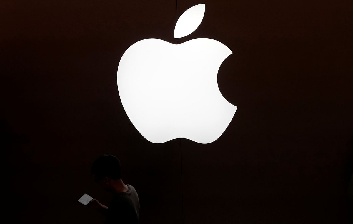 A man looks at the screen of his mobile phone in front of an Apple logo outside its store in Shanghai. Reuters file photo
