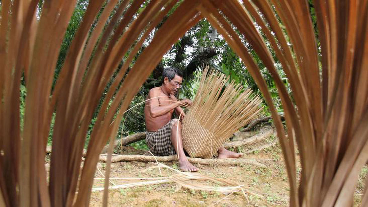 An indigenous man makes Khalung, a traditional basket, made of bamboo in Khagrachhari on 10 August. Photo: Neerob Chowdhury