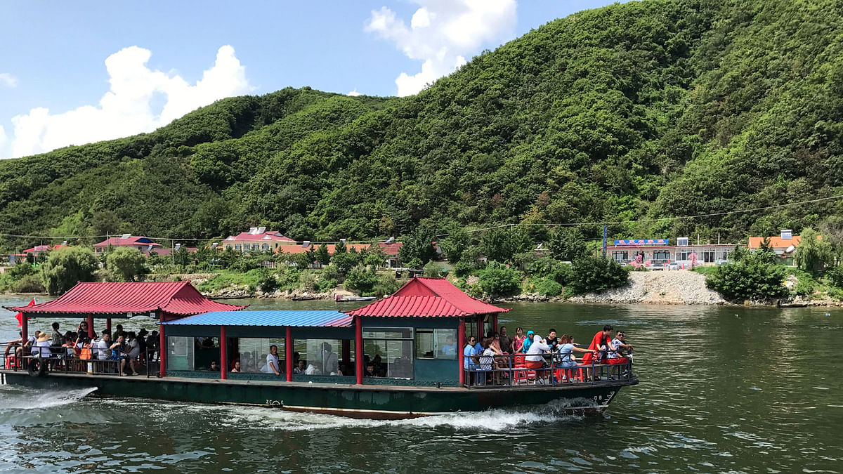 Chinese tourists are seen a boat taking them from the Chinese side of the Yalu River for sightseeing close to the shores of North Korea, near Dandong. Reuters