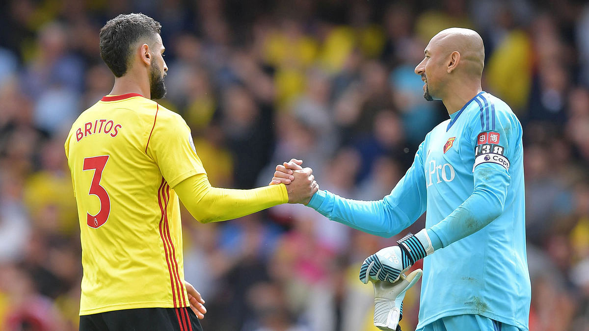 Watford`s Uruguayan defender Miguel Britos (L) shakes hands with Watford`s Brazilian goalkeeper Heurelho Gomes following the English Premier League football match between Watford and Liverpool at Vicarage Road Stadium in Watford, north of London on 12 August, 2017. Photo: AFP