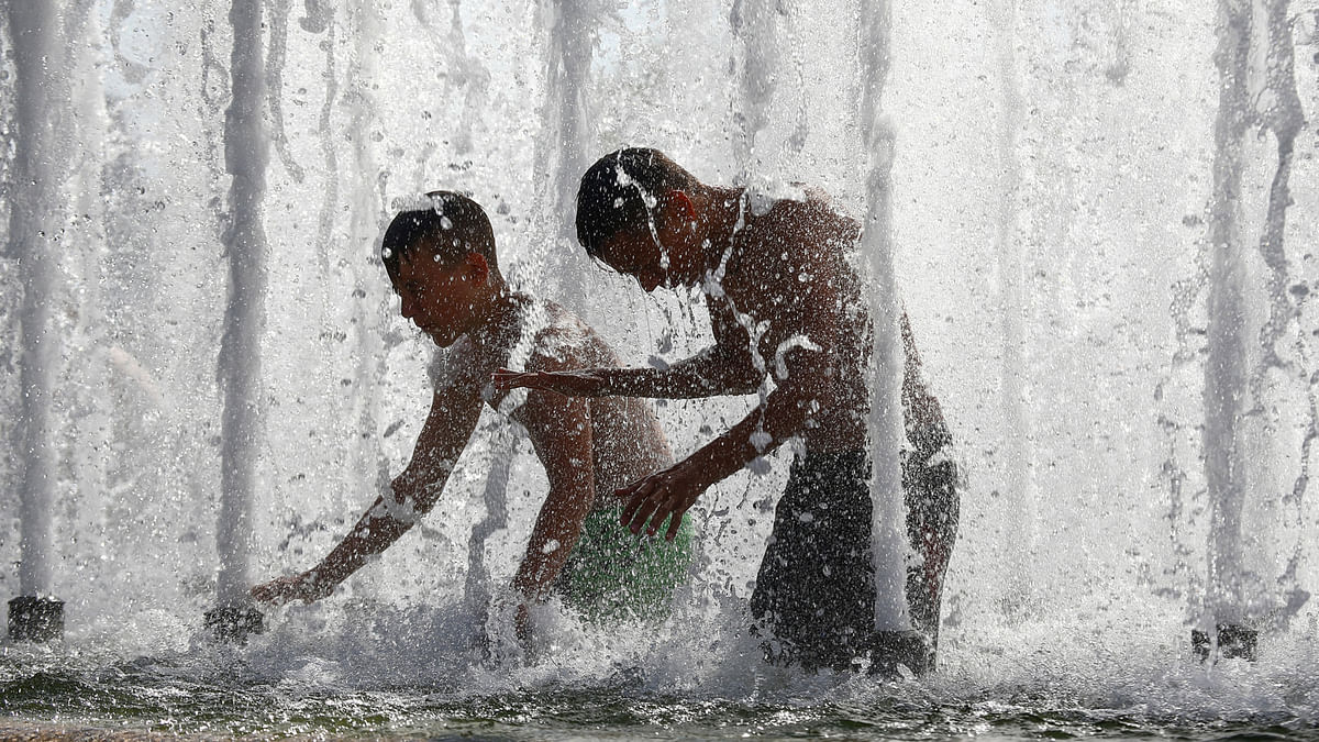 Boys cool themselves in a fountain during hot summer day in central Minsk, Belarus. Photo: Reuters
