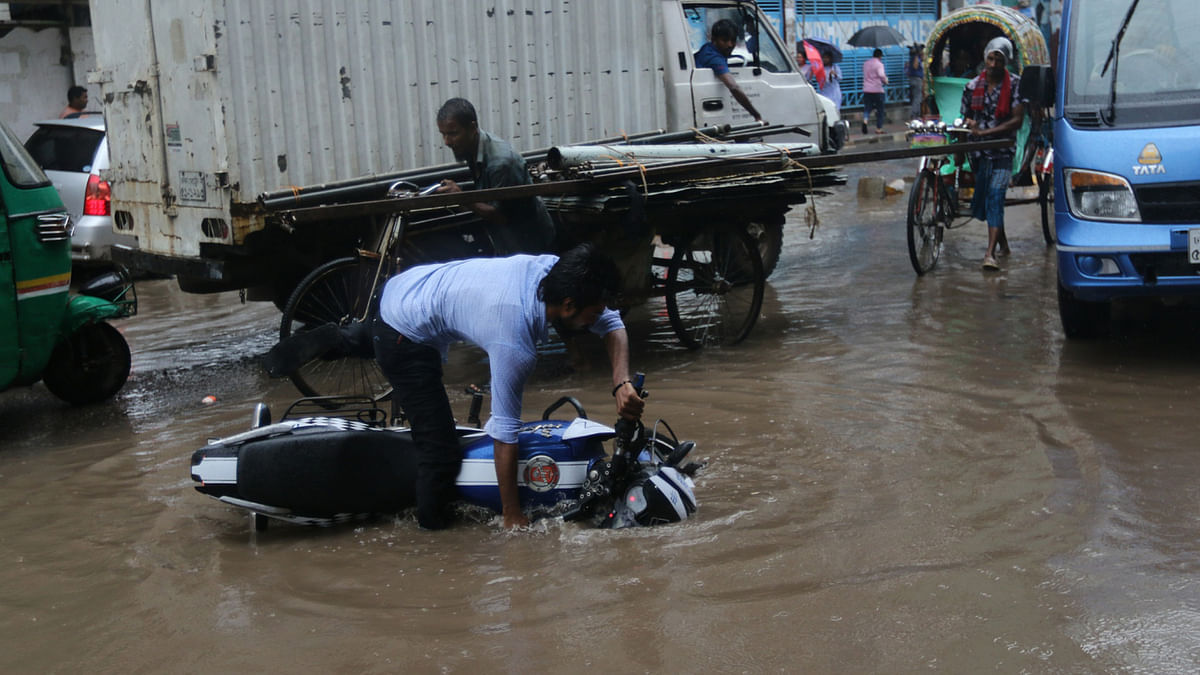 A motorcycle falls into a pothole in front of South Point School in Malibagh Coudhuripara area. Photo: Abdus Salam