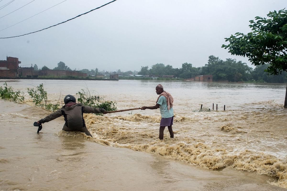Nepali residents helping each other to cross flooded area at Birgunj Parsa district, some 200km south of Kathmandu, on 13 August, 2017. Photo: AFP