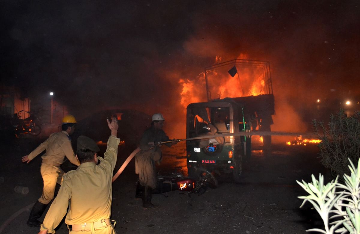 Pakistani firefighters use hoses to try to extinguish burning vehicles after a blast in Quetta. Photo: AFP