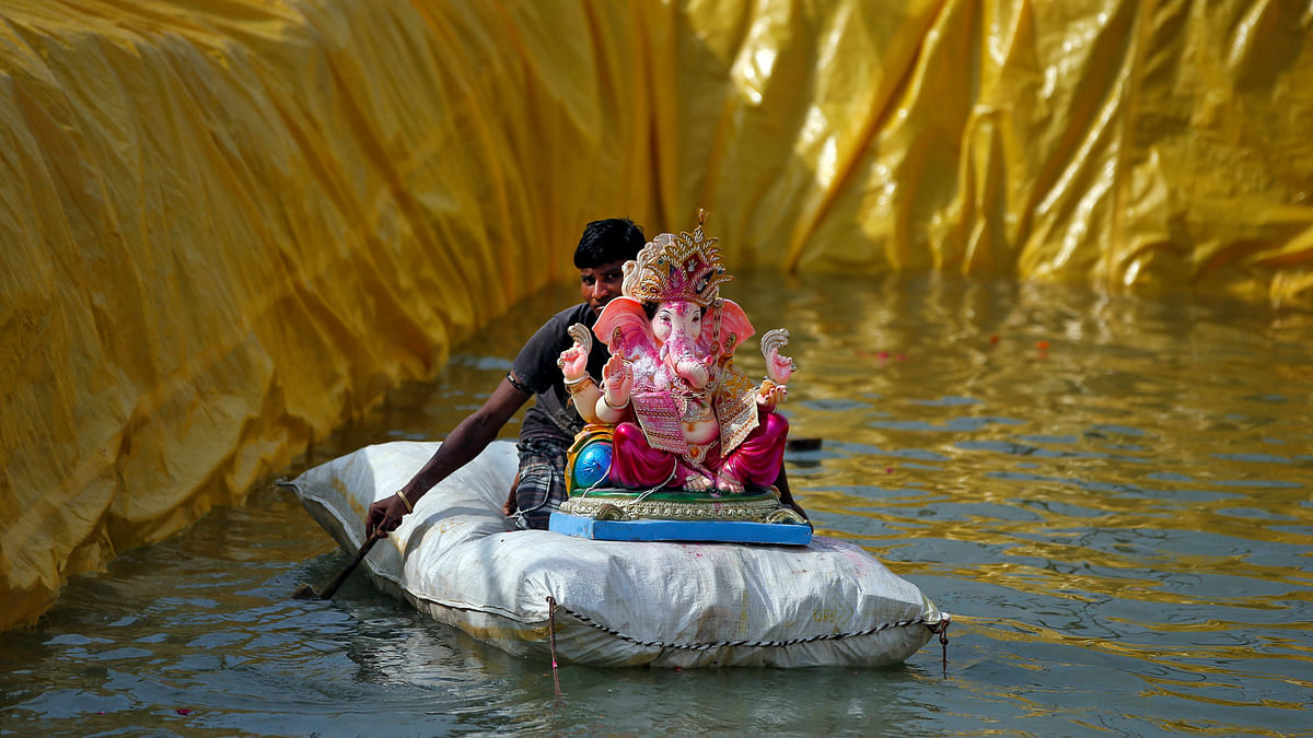 A man transports an idol of the Hindu god, Ganesh, the deity of prosperity, on a makeshift raft after it was immersed in a pond on the second day of the ten-day long Ganesh Chaturthi festival in Ahmedabad, India, 26 August 2017. Photo: Reuters