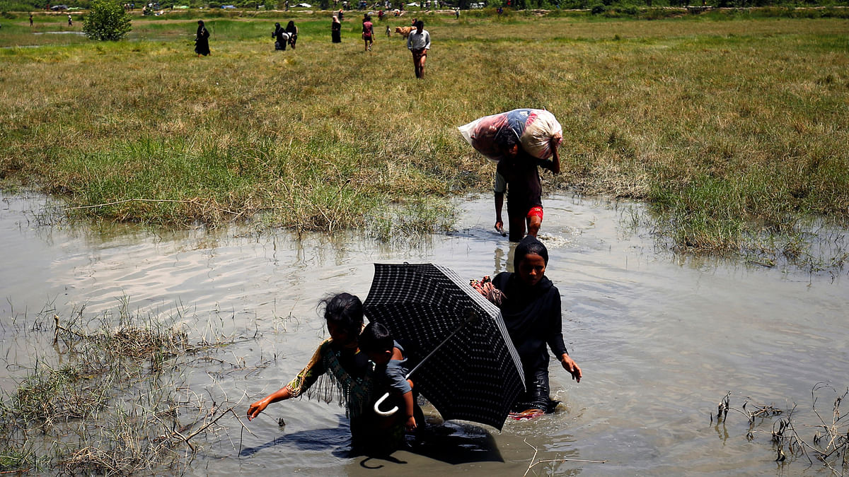 Rohingya people make their way through water as they try to come to the Bangladesh side from No Man’s Land after a gunshot being heard on the Myanmar side, in Cox’s Bazar, Bangladesh August 28, 2017. Reuters