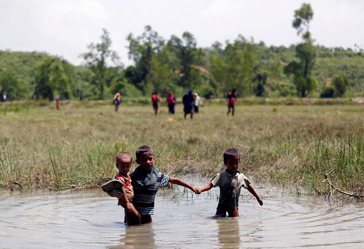 Rohingya children make their way through water as they try to come to the Bangladesh side from No Man’s Land after a gunshot being heard on the Myanmar side, in Cox’s Bazar, Bangladesh August 28, 2017. Reuters