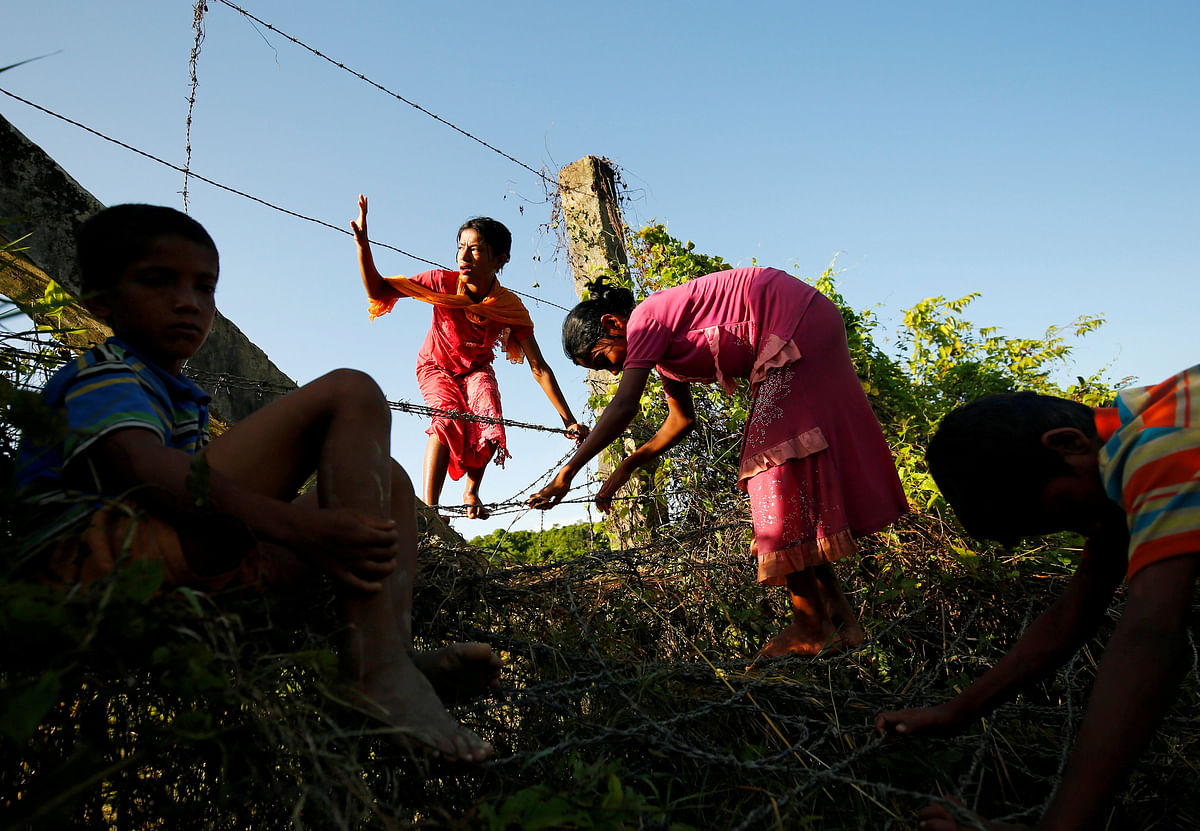 Rohingya children cross the Bangladesh-Myanmar border fence as they try to enter Bangladesh in Bandarban, an area under Cox`s Bazar authority. Reuters