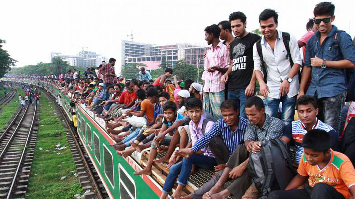 Homebound people, eager to celebrate the Eid-ul-Azha with the family, travel on the roof of a train risking their lives. This picture was taken from Airport Rail Station in Dhaka on Friday. Photo: Prothom Alo