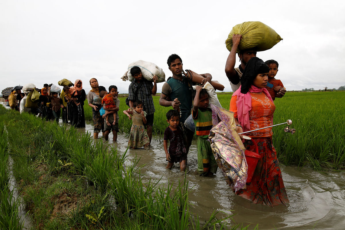 A group of Rohingya refugee people walk in the water after crossing the Bangladesh-Myanmar border in Teknaf. Reuters
