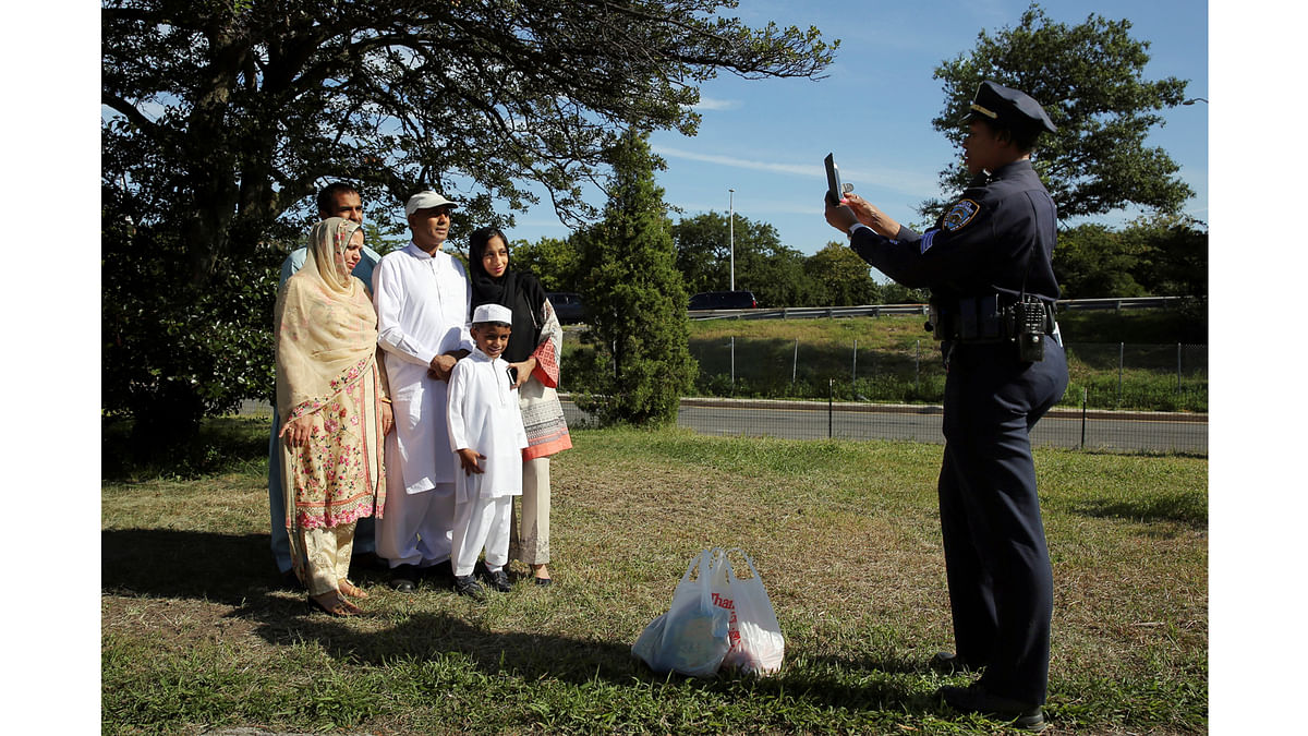 A police officer takes photos of a Muslim family after Eid al-Adha prayers in Bensonhurst Park in Brooklyn, New York. Reuters