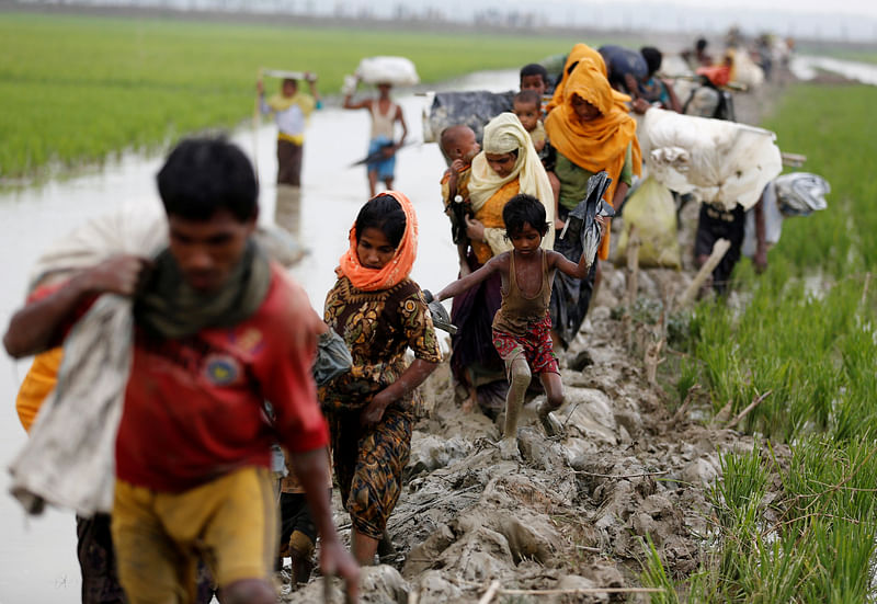 Rohingya refugees walk on the muddy path after crossing the Bangladesh-Myanmar border in Teknaf. Reuters file photo