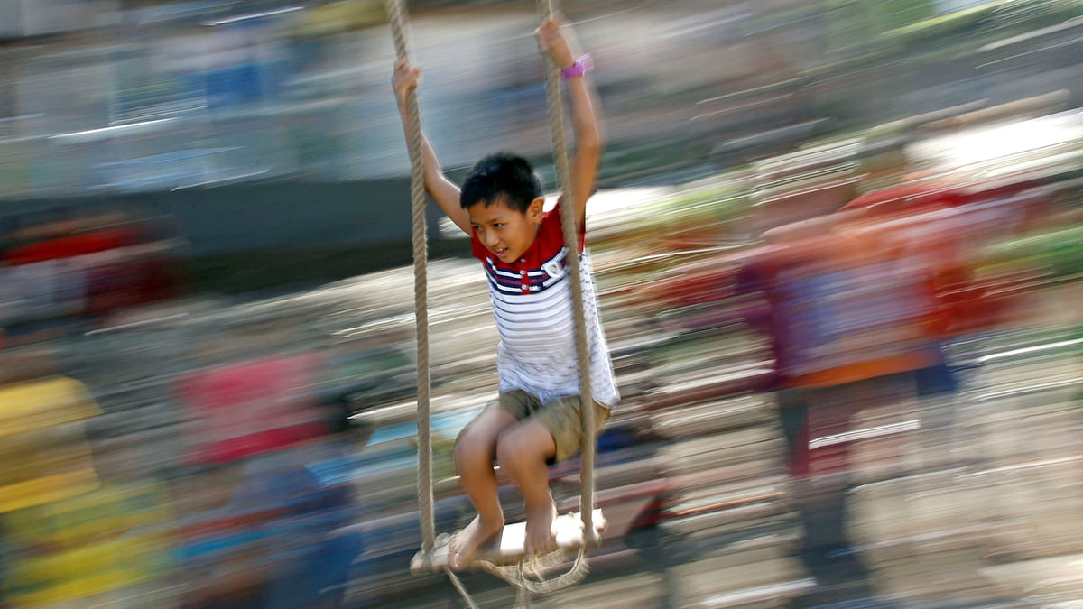 A boy plays on a traditional swing during Dashain, the biggest religious festival for Hindus in Nepal, in Kathmandu, Nepal on 23 September 2017. Photo: Reuters