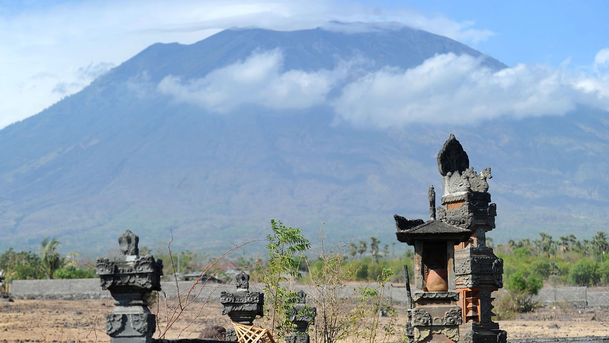 A general view shows Mount Agung behind Balinese Hindu temples seen from Karangasem on the Indonesian resort island of Bali on 23 September 2017. Authorities have raised alert levels for a volcano on the Indonesian resort island of Bali after hundreds of small tremors stoked fears it could erupt for the first time in more than 50 years. Photo: AFP
