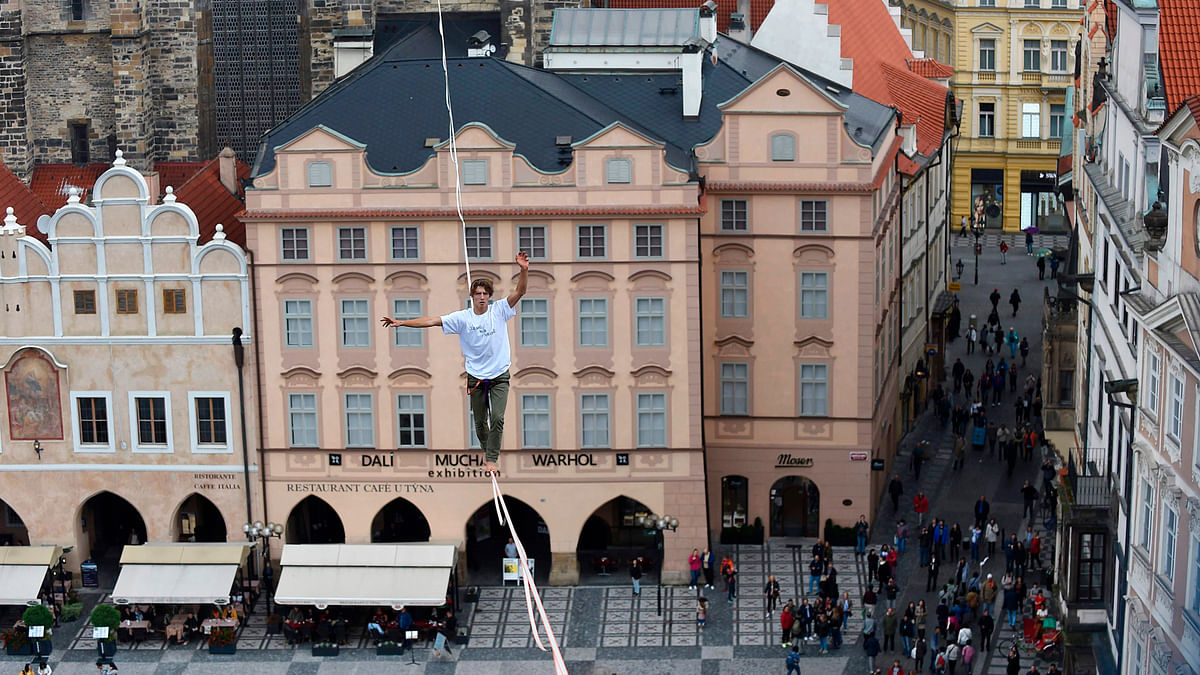 A man balances on a rope attached highly over the Old Town square as part of the `Zivot na hrane` campaign supporting people diagnosed with diabetes on 25 September 2017 in Prague, Czech Republic. Photo: AFP