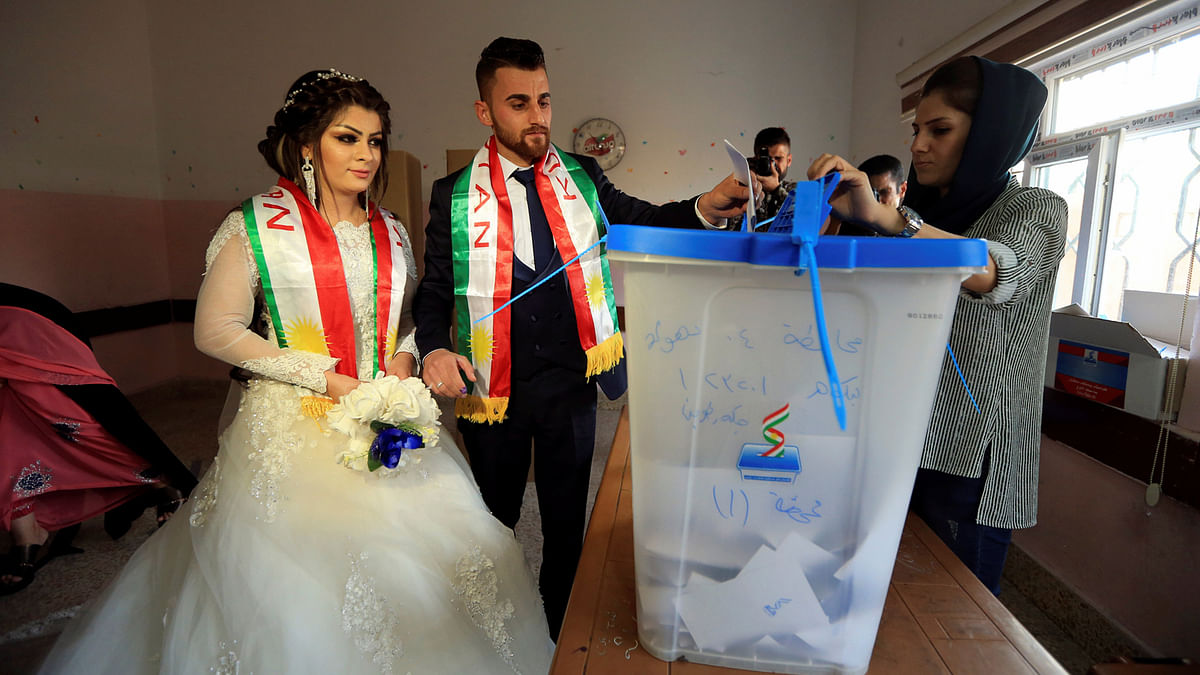 A groom and a bride cast their votes at a polling station during Kurds independence referendum in Duhok, Iraq on 25 September 2017. Photo: Reuters