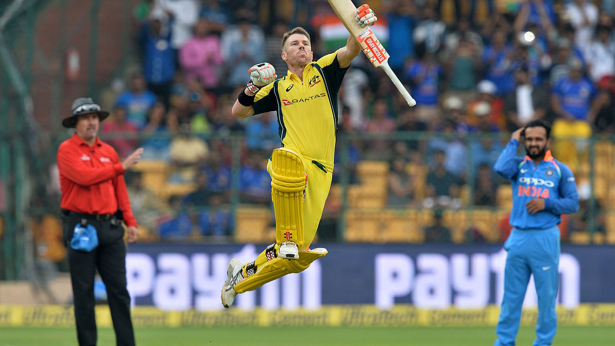 Australian cricketer David Warner jumps to celebrate his century (100 runs) during the fourth one day international (ODI) match in the ongoing India-Australia cricket series at the M Chinnaswamy Stadium in Bangalore on 28 September. Photo: AFP