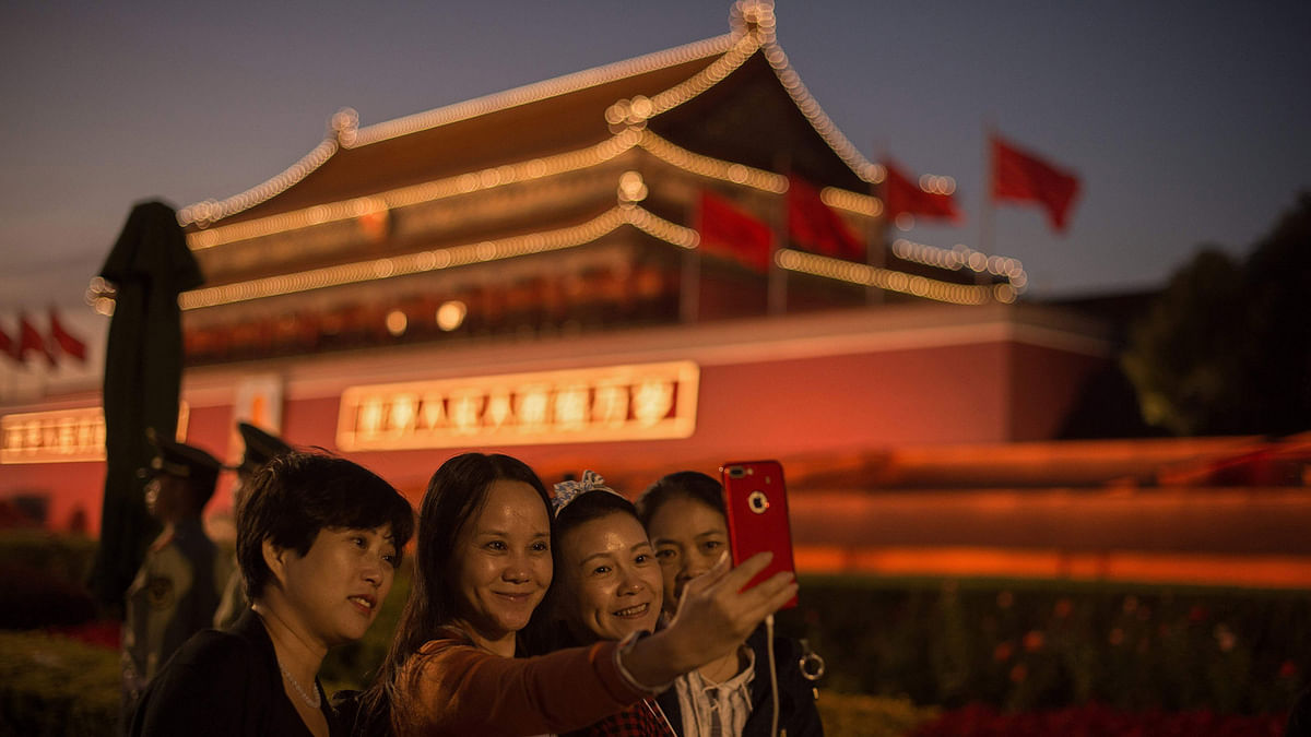 People take a group selfie in front of the Forbidden City in Beijing on 28 September 2017. China will convene its 19th Party Congress on 18 October, said the state media, a key meeting held every five years where president Xi Jinping is expected to receive a second term as the ruling Communist Party’s top leader. Photo: AFP