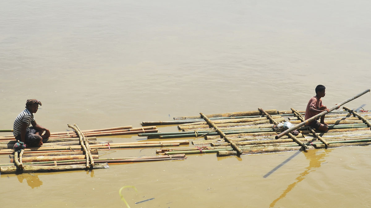 Locals floating bamboo and wood on Maini river for sale in Tebhangchhara of Dighinala upazila of Khagrachhari on Monday. Photo: Palash Barua