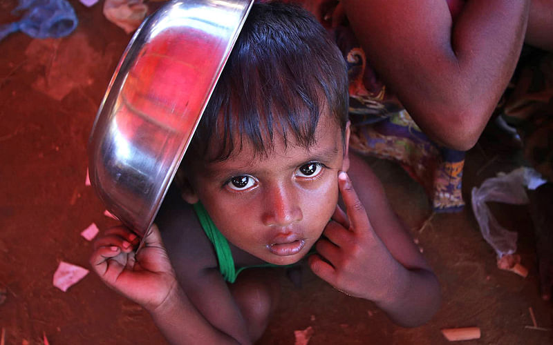 A minor waits for lunch at Balukhali refugee camp at Ukhia, Cox’s Bazar on Sunday. Photo: Sabina Yesmin