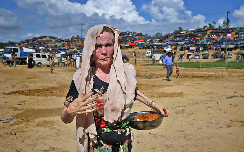 An elderly Rohingya woman collects rice and meat distributed on the eve of Ashura at Balukhali refugee camp in Ukhia, Cox’s Bazar on Sunday. Photo: Sabina Yesmin