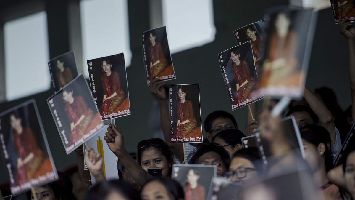 People attending an interfaith prayer ceremony lift portraits of Myanmar`s civilian leader Aung San Suu Kyi on 10 October, 2017. Photo: AFP