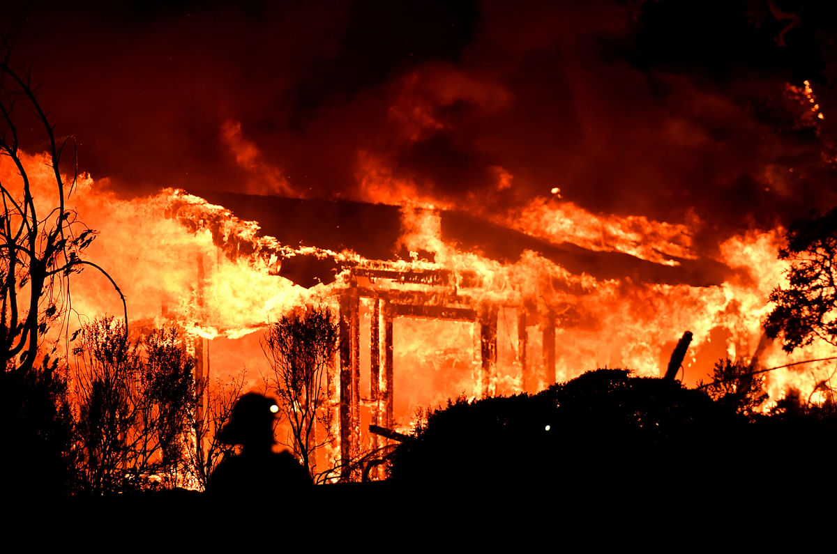Firefighters assess the scene as a house burns in the Napa wine region of California on 9 October, 2017, as multiple wind-driven fires continue to ravage the area burning structures and causing widespread evacuations. Photo: AFP