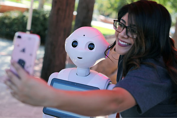 San Marcos student Amaris Gonzalez takes a selfie with `Pepper` an artificial Intelligence project utilizing a humanoid robot from French company Aldebaran and reprogrammed as an assistant for students attending Palomar College in San Marcos, California, US 10 October 2017. Photo: Reuters