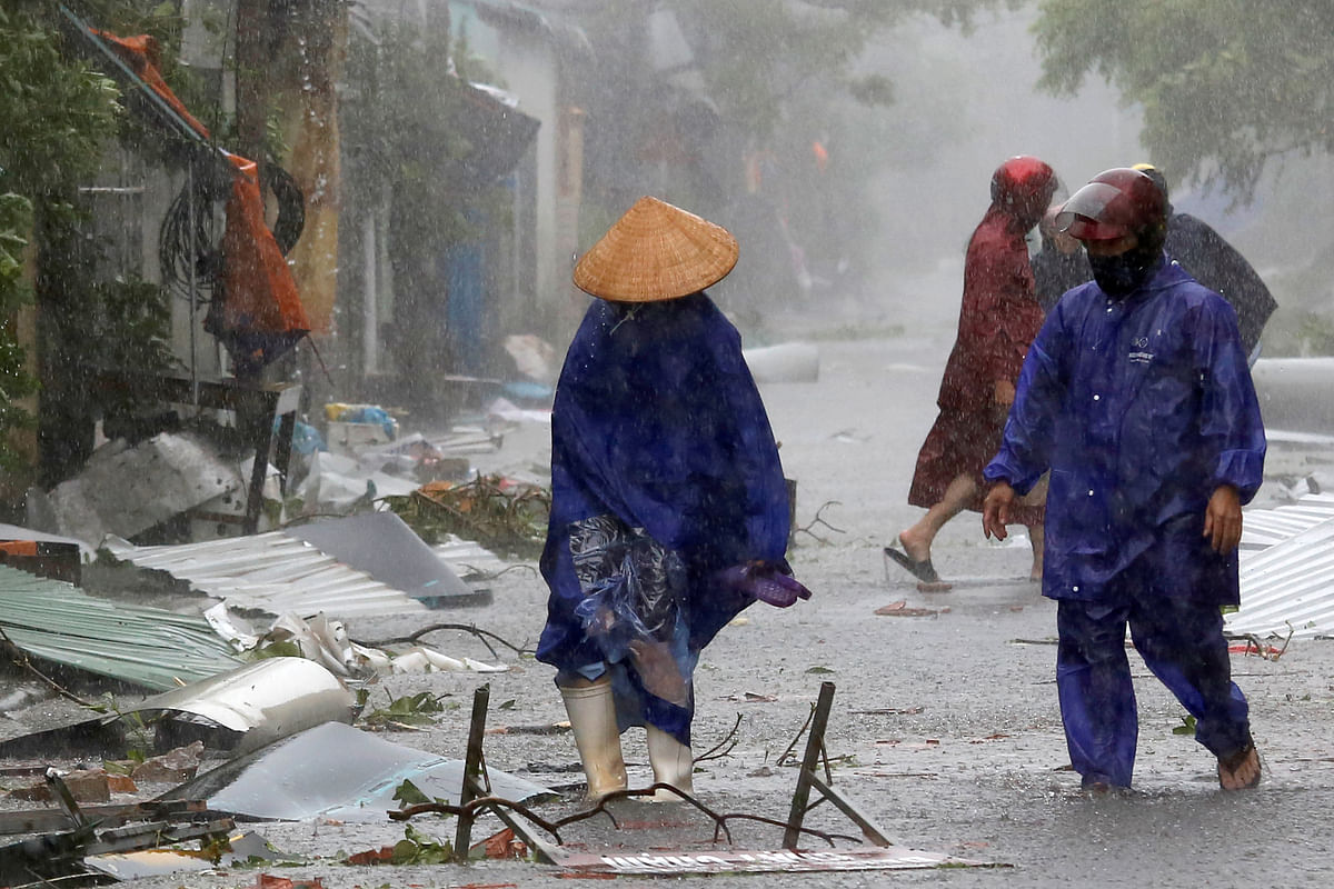People remove debris on a road as Doksuri storm hits Ha Tinh province, Vietnam. Reuters