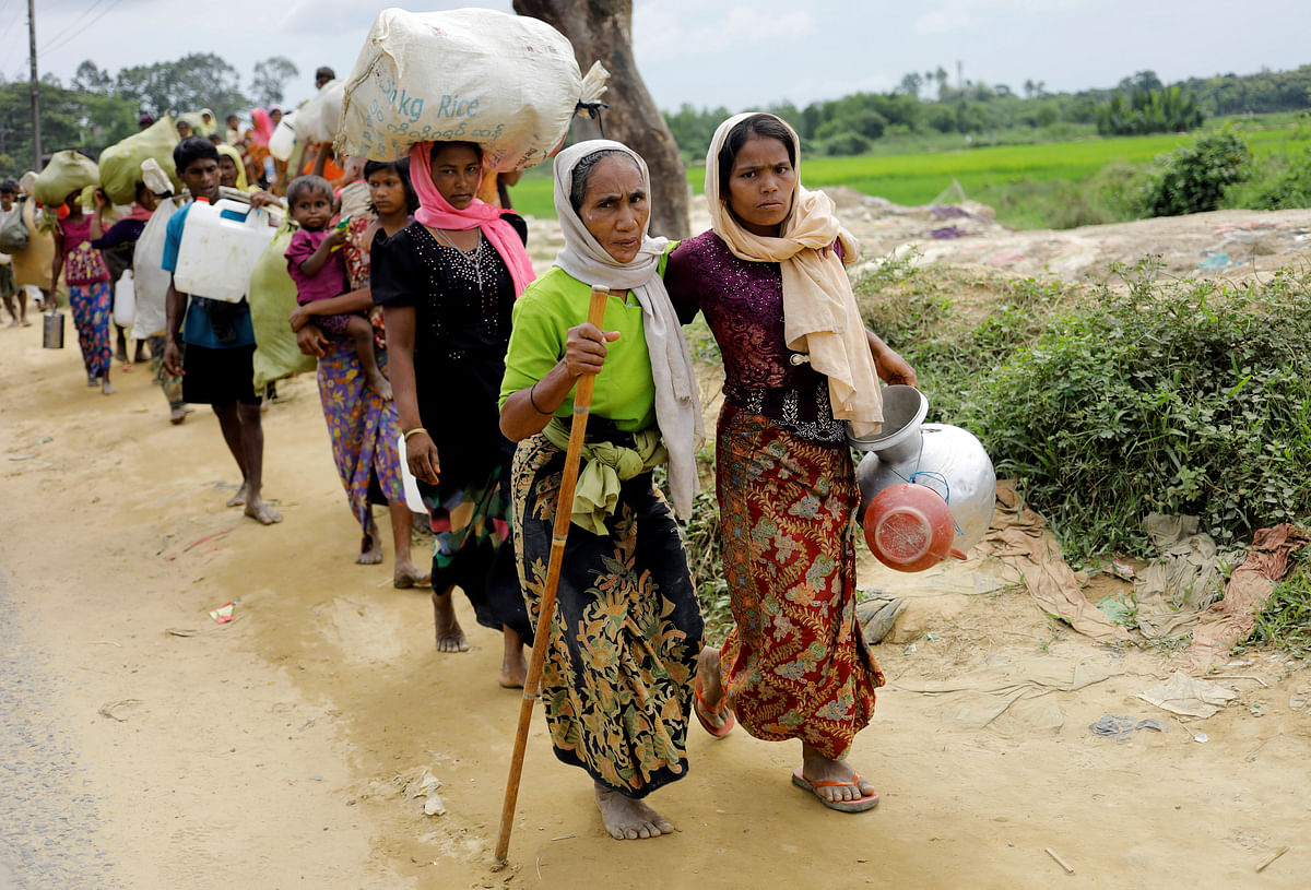 Rohingya refugees, who crossed the border from Myanmar two days earlier, walk after they received permission from the Bangladesh army to continue their way to Kutupalong refugee camp, near Cox`s Bazar. Reuters