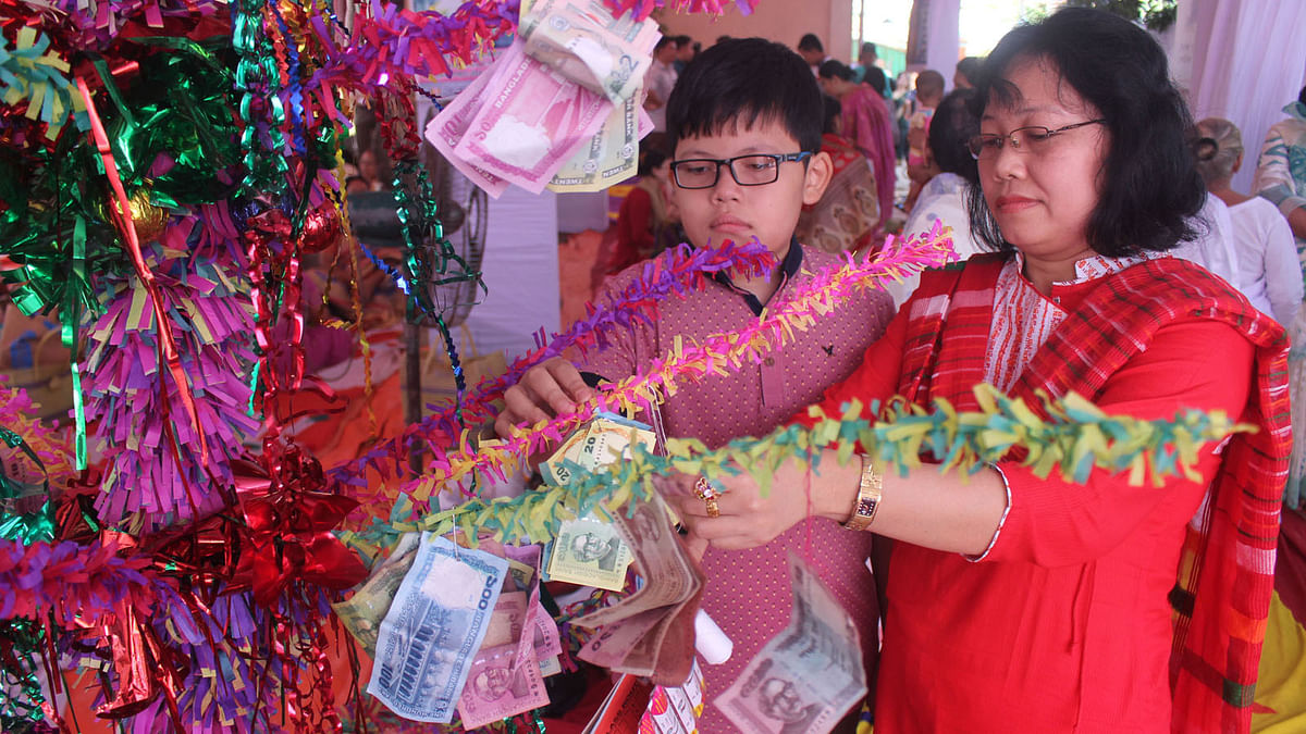 The people of Buddhist community keep busy in decorating trees with currency notes on the occasion of the greatest religious festival Kothin Chibor Dan at Akhalia of Sylhet on 27 October 2017. Photo: Anis Mahmud